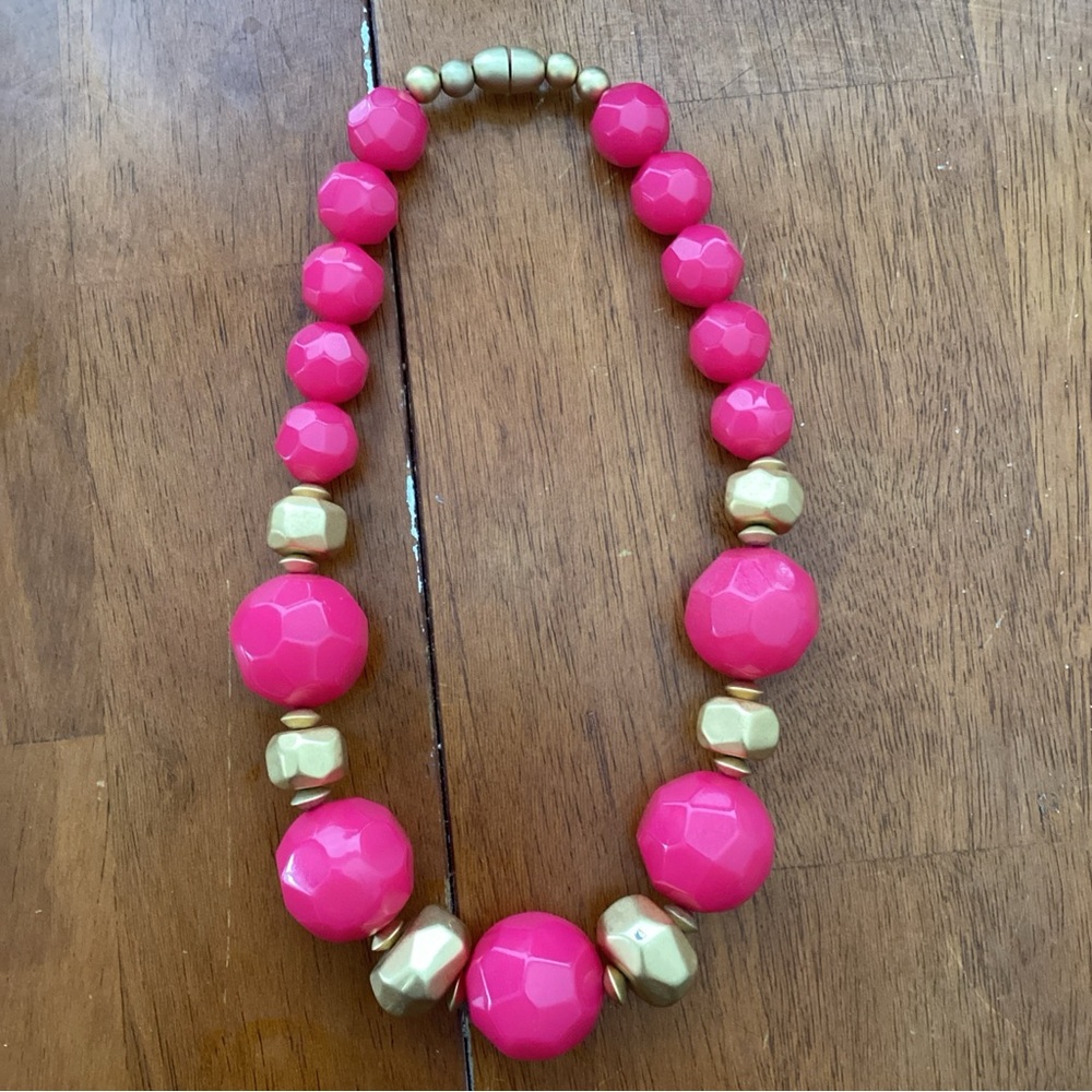 Eye-catching necklace with vibrant pink and gold beads.